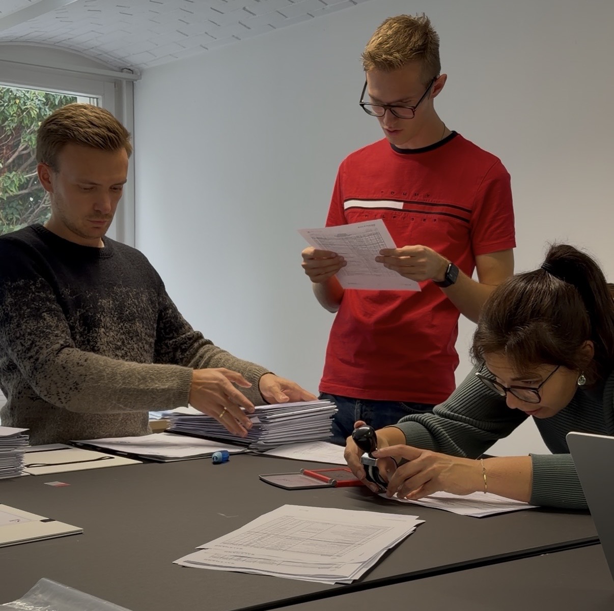 Team von Salzmann Ingenieure beim Sortieren und Stempeln der Einreichunterlagen für den Sessellift Garfrescha