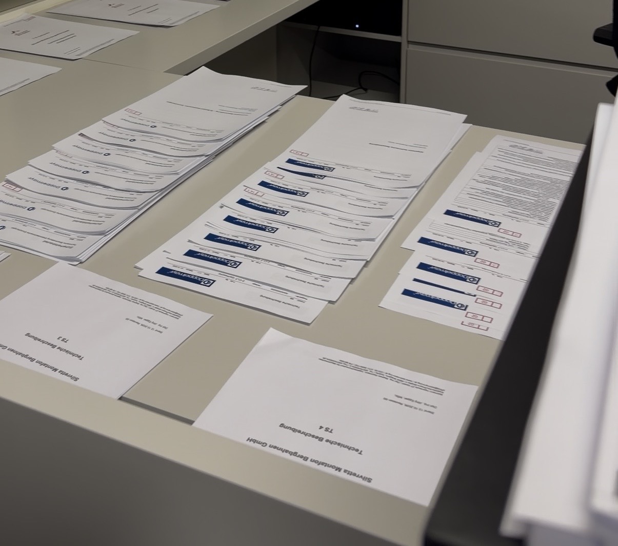 Sortierte technische Beschreibungen und Unterlagen auf den Schreibtischen im Büro