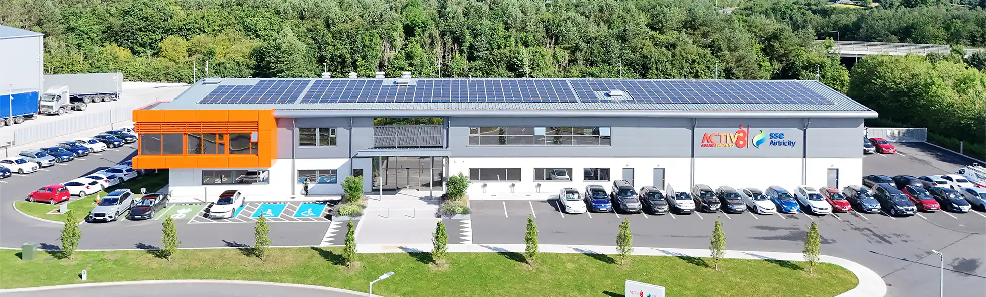 Activ8 headquarters with solar panels on roof and cars parked outside