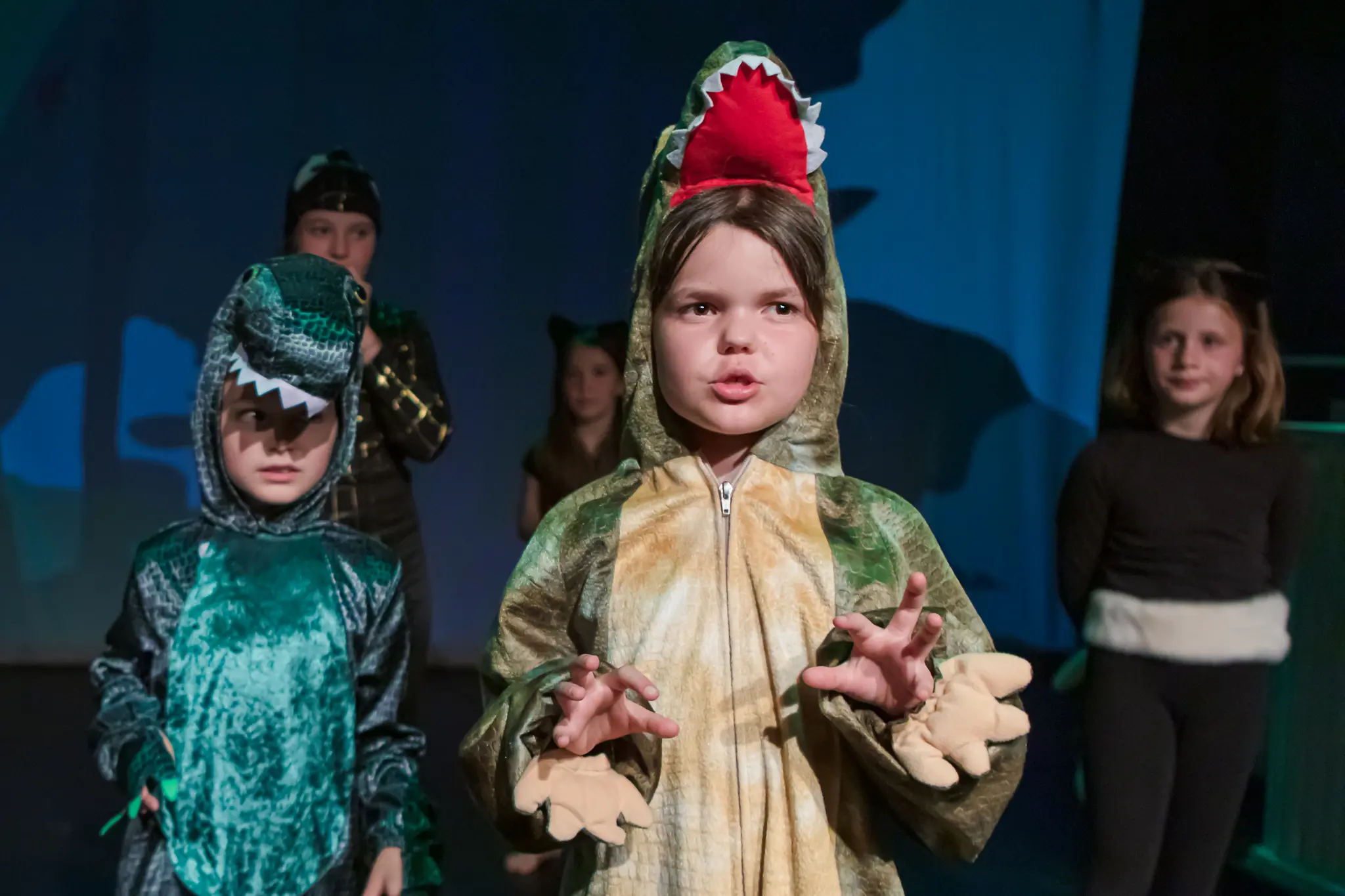 Jeune comédienne en costume de dinosaure sur scène