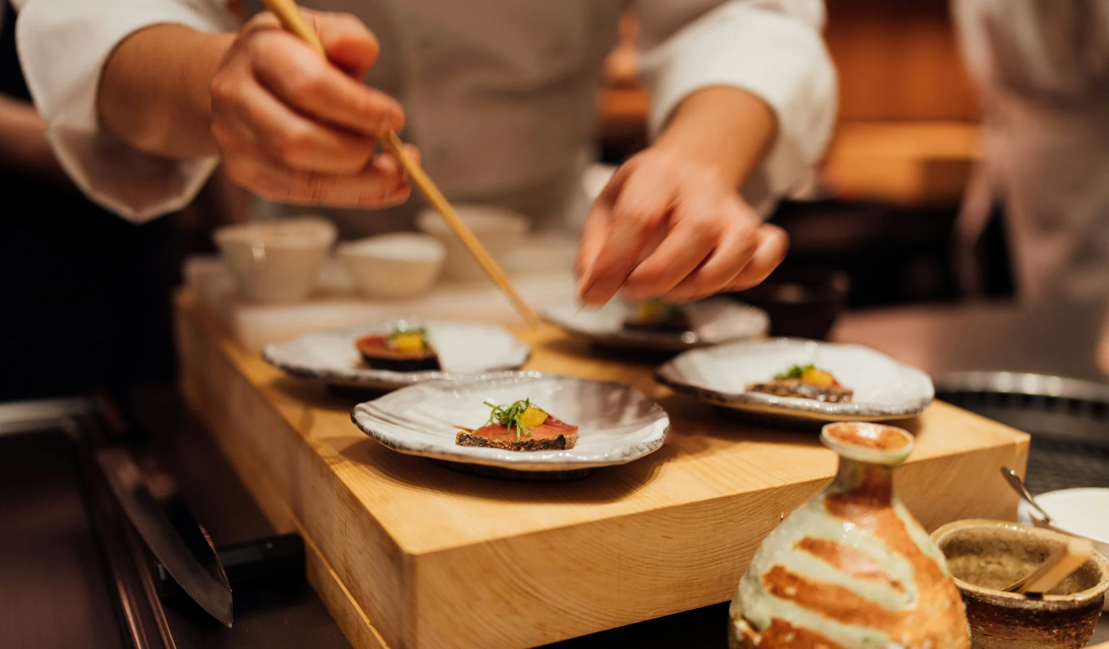 Chef dressant une assiette aux baguettes pour un déjeuner ou dîner avec chef privé KEEZE