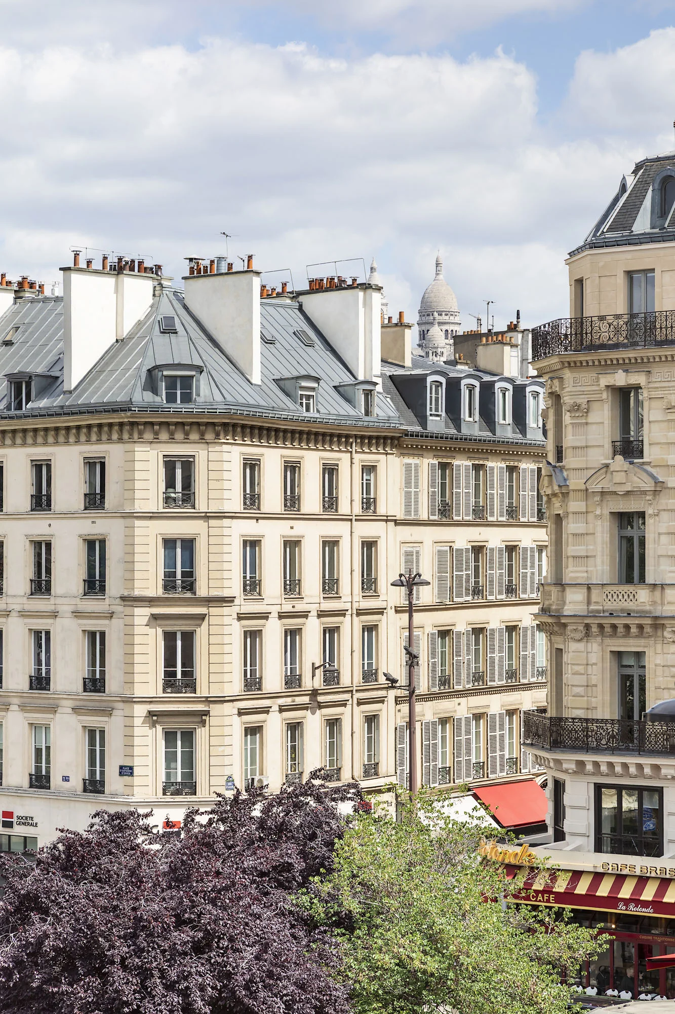 Vue sur les toits parisiens et le Dôme du Sacré-Cœur depuis une terrasse, ambiance de fête de fin d'année à Paris avec KEEZE