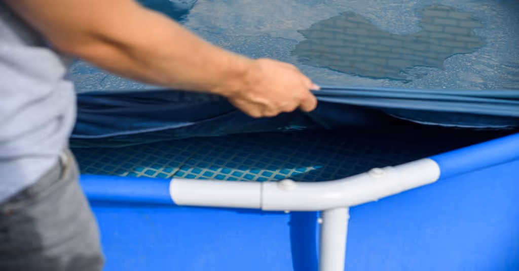 A close-up of someone putting a royal blue cover over their residential swimming pool to keep debris out.