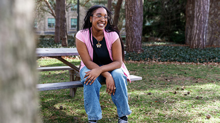 Student sitting down on a bench.