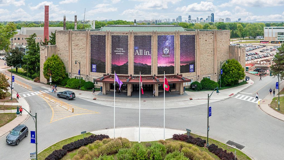 An aerial shot of Alumni Hall at Western University with All in banners.