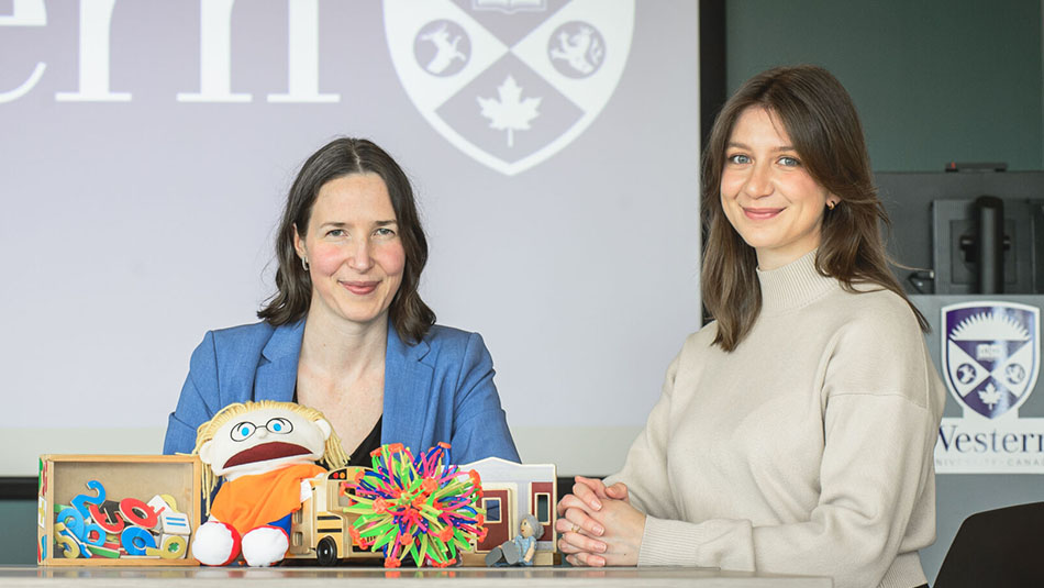 Katelyn Bryant and Abigail Withers sitting with children's toysin the Mary J Wright Clinic