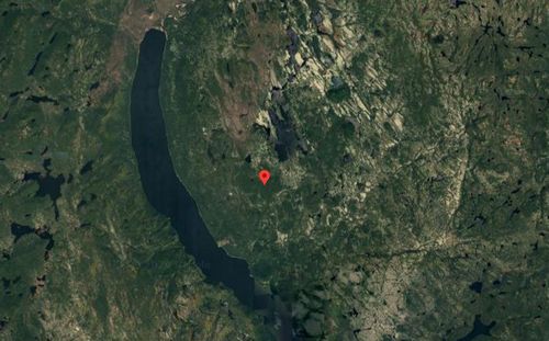 Google Maps satellite view screenshot with a red pin in the center