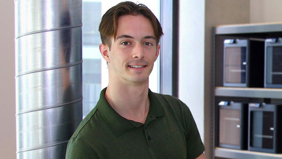 Engineering student Troy Leishman standing in front of a bank of 3D printers in the digital makerspace at Western's Morrissette Entrepreneurship