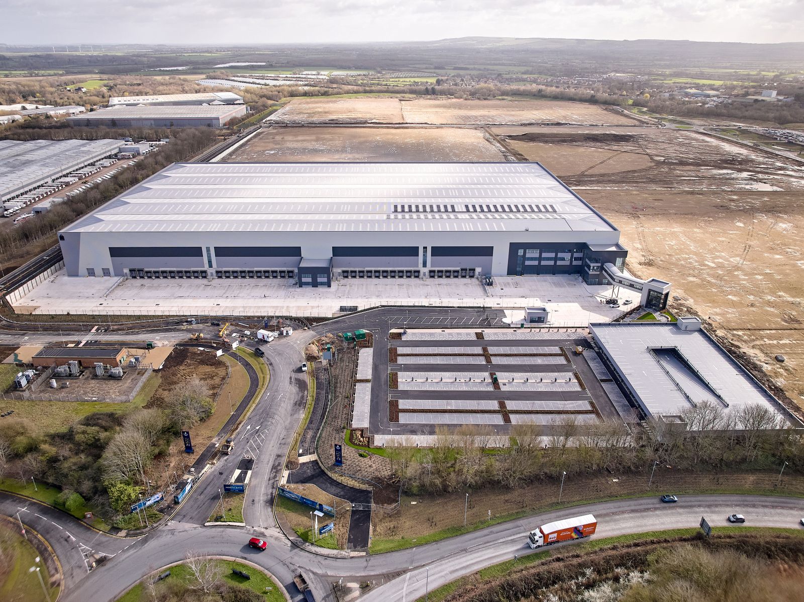 Aerial view of Panattoni Park in Swindon, a large warehouse beside a roundabout with open land beyond