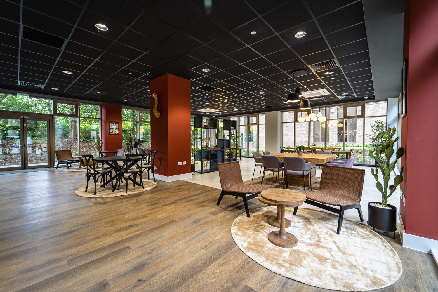 Communal lounge at The Oaks student accommodation, with timber floors, lounge chairs and study tables
