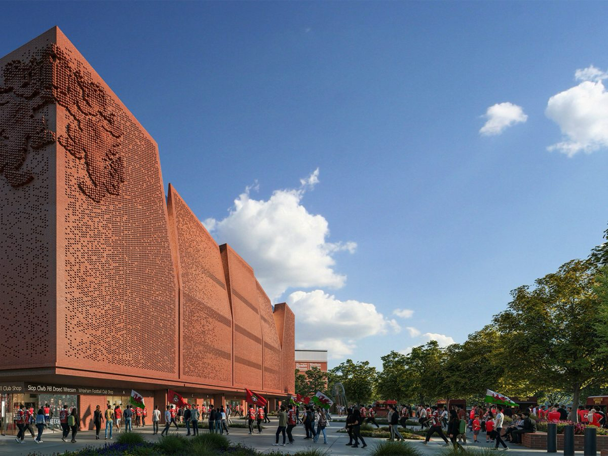Wrexham AFC's new Kop Stand, with a patterned red brick facade, and fans gathering outside