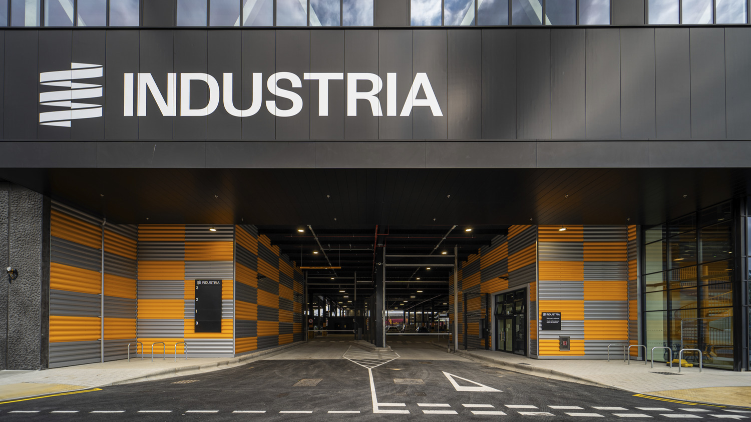 Entrance to Industria in Barking, with the Industria sign above a yellow and grey clad loading level