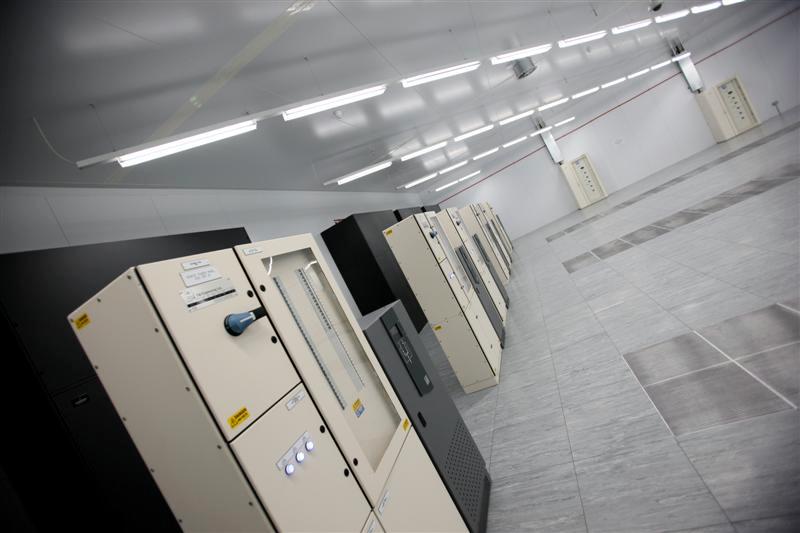 Data hall at Digital Realty, Redhill, with rows of electrical cabinets under strip lighting