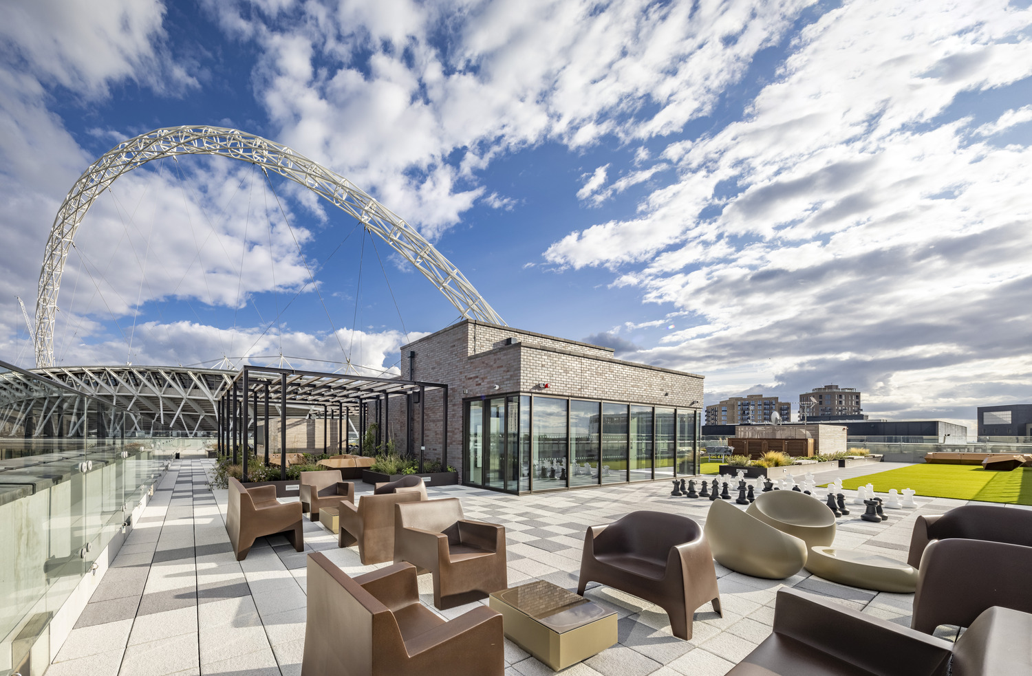 Roof terrace with lounge seating at Wembley Park, looking towards Wembley Stadium's arch