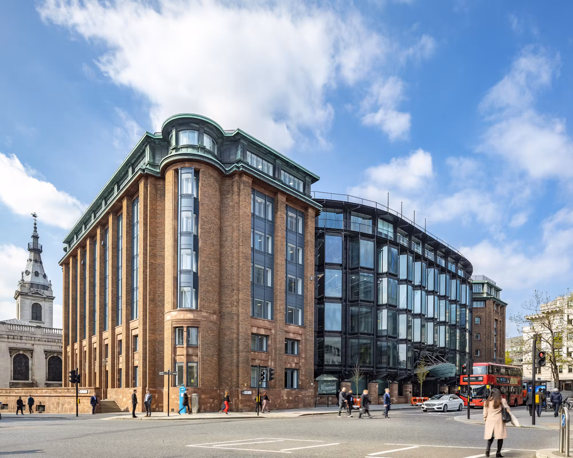 Bracken House seen from the street, its pink brick and sandstone wings either side of a bronze-framed glazed centre