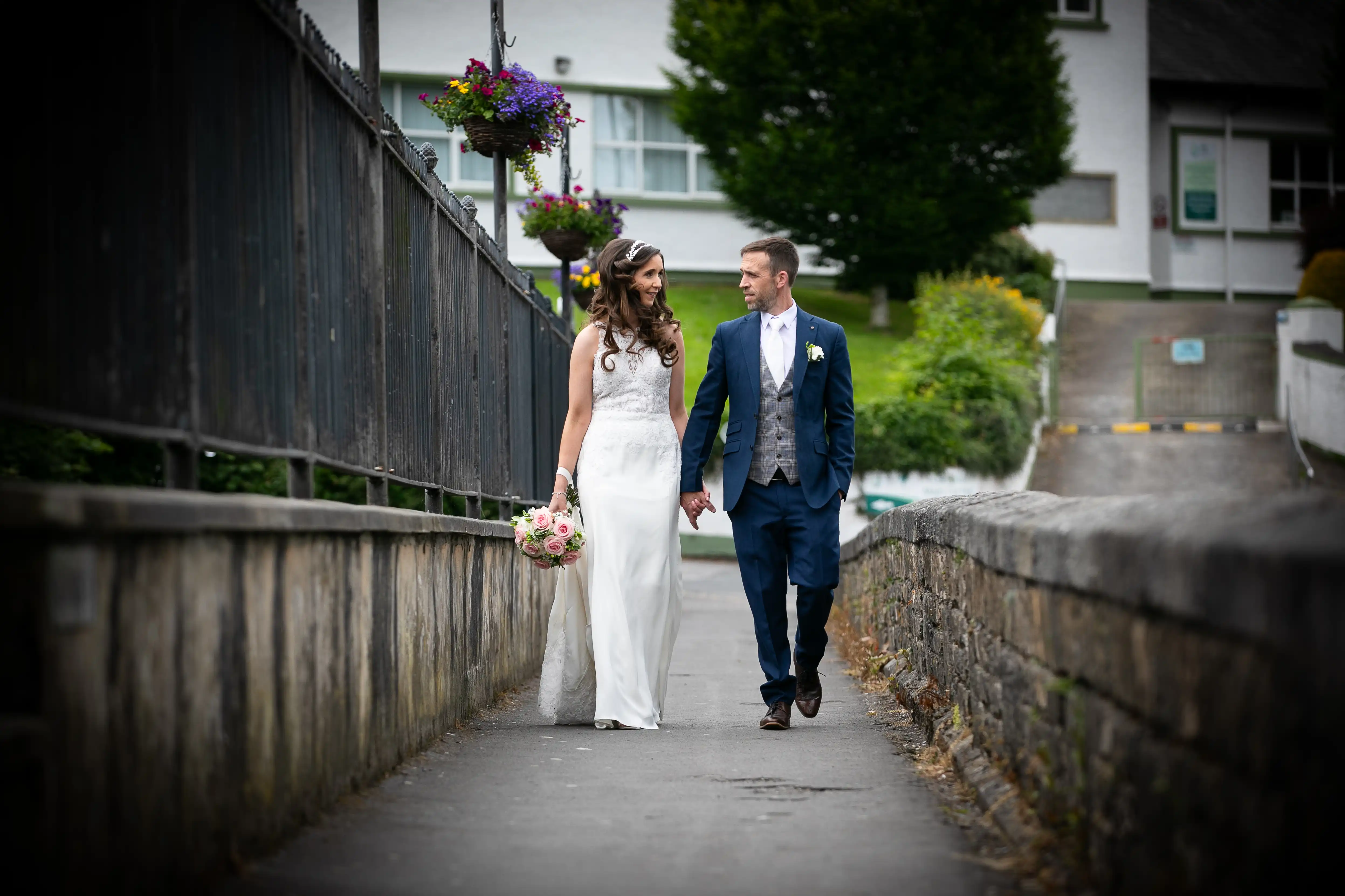Newly married couple smiling and holding hands while walking
