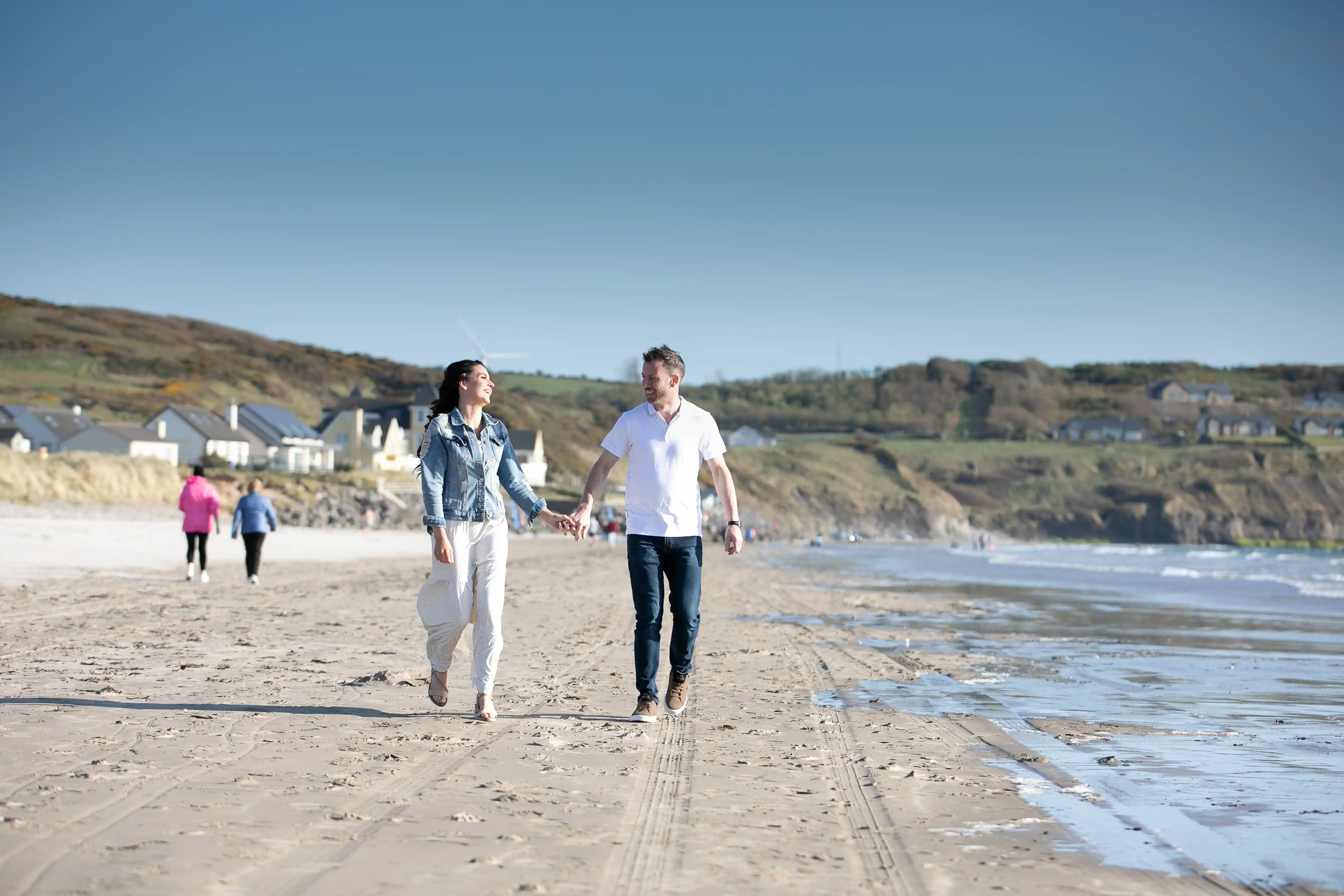 Couple holing hands and smiling on beach