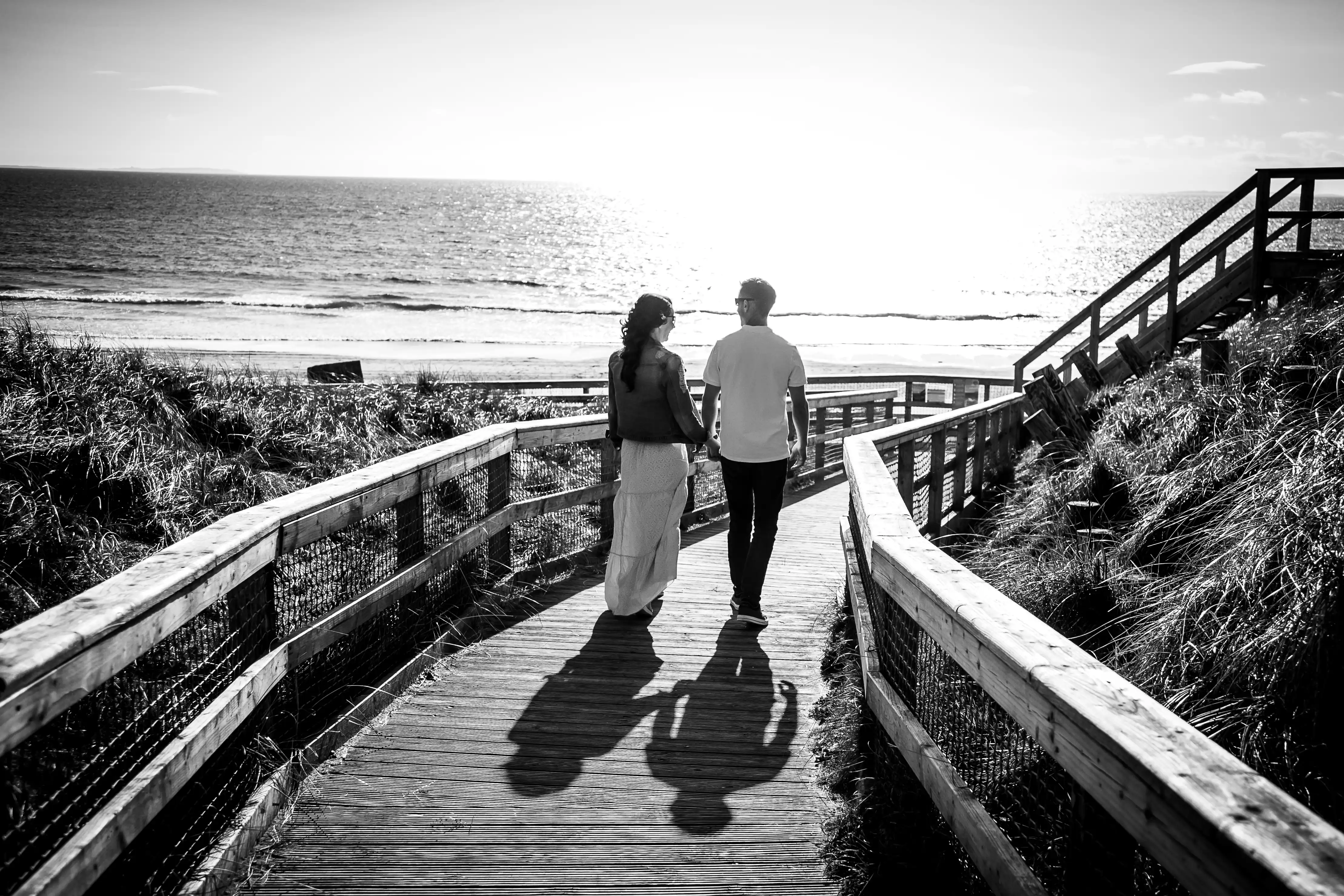 Couple holding hands heading towards beach