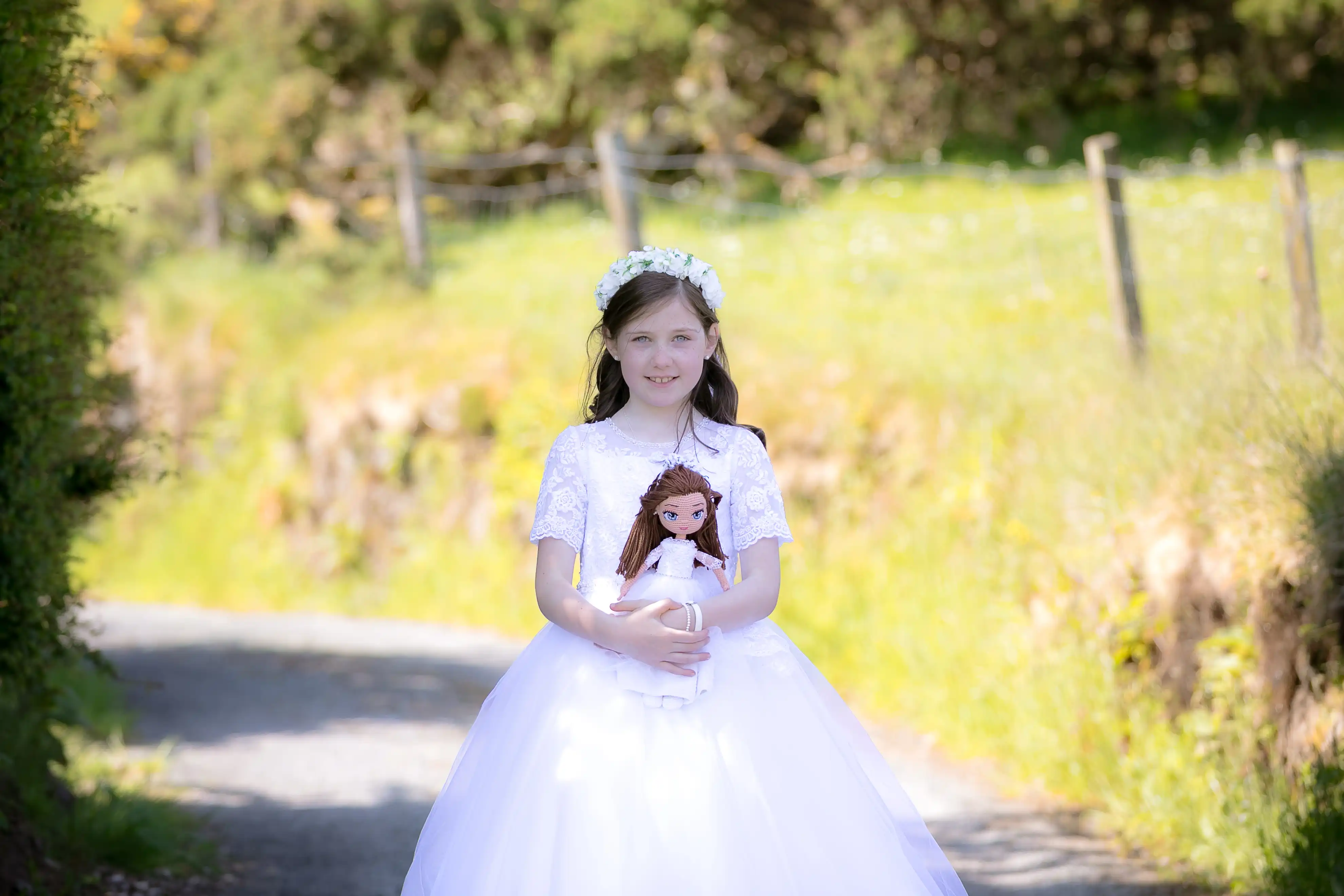 Little girl smiling holding doll on communion day