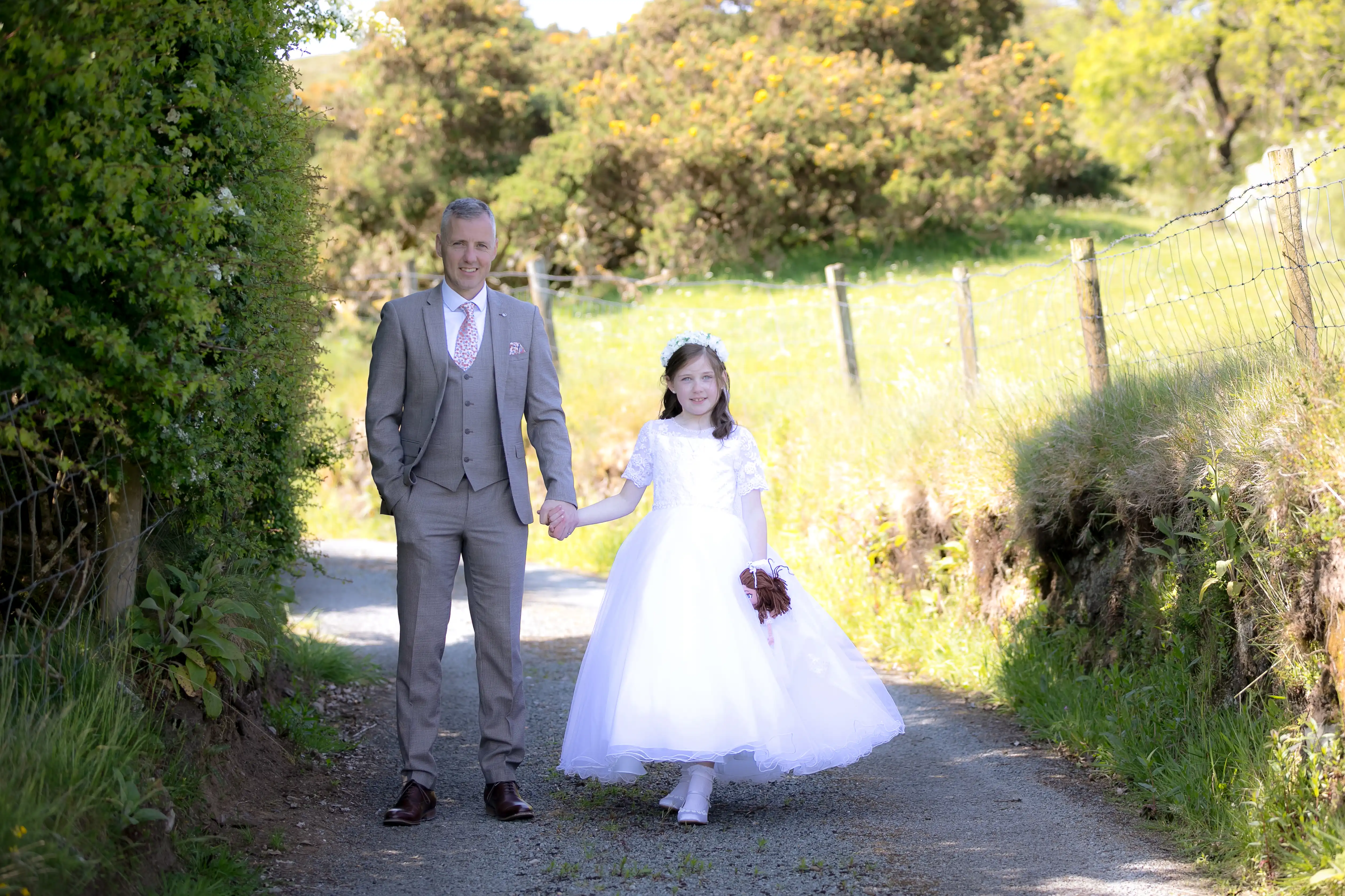 Dad and daughter holding hands on her communion day