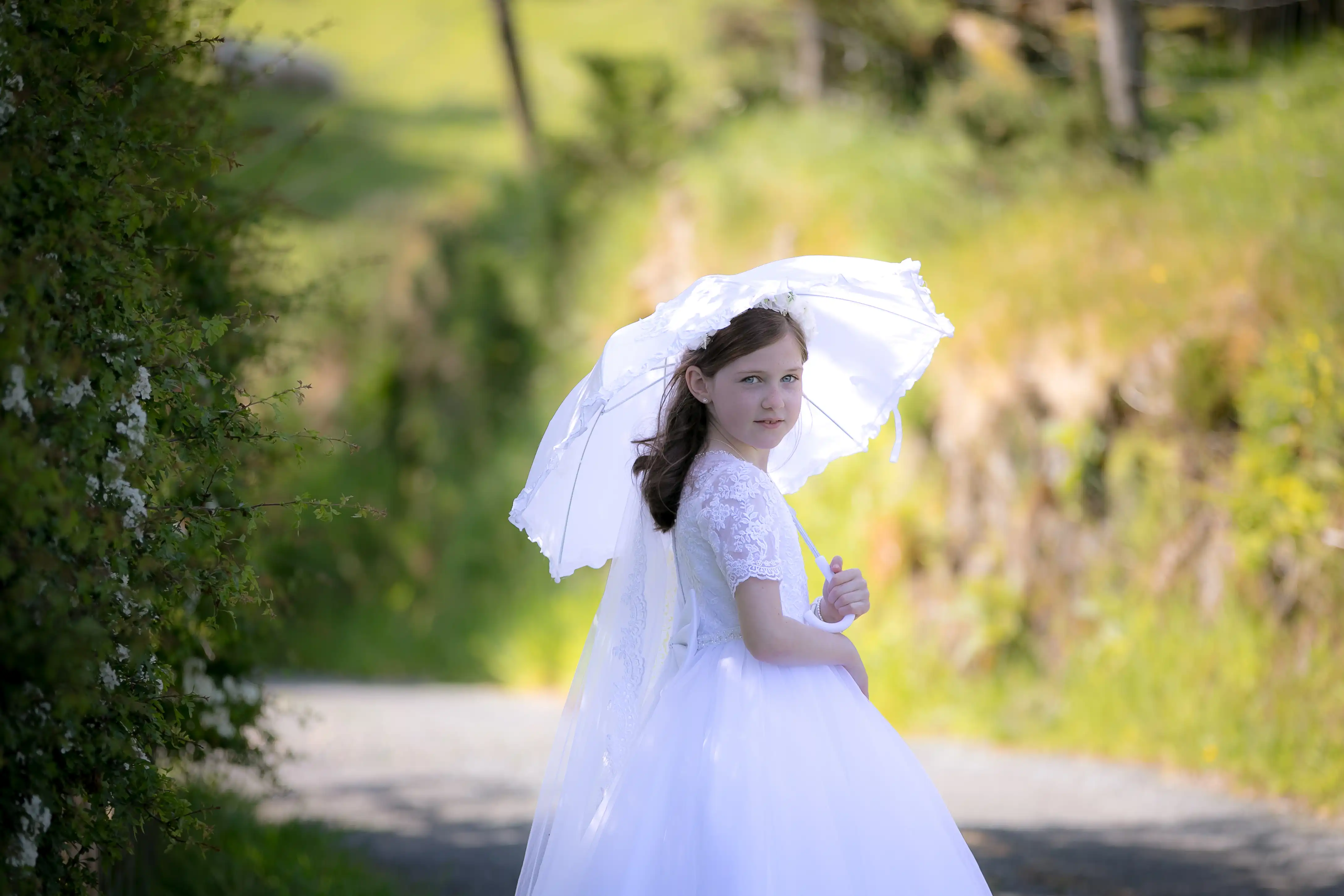 Little girl holding umbrella on communion day