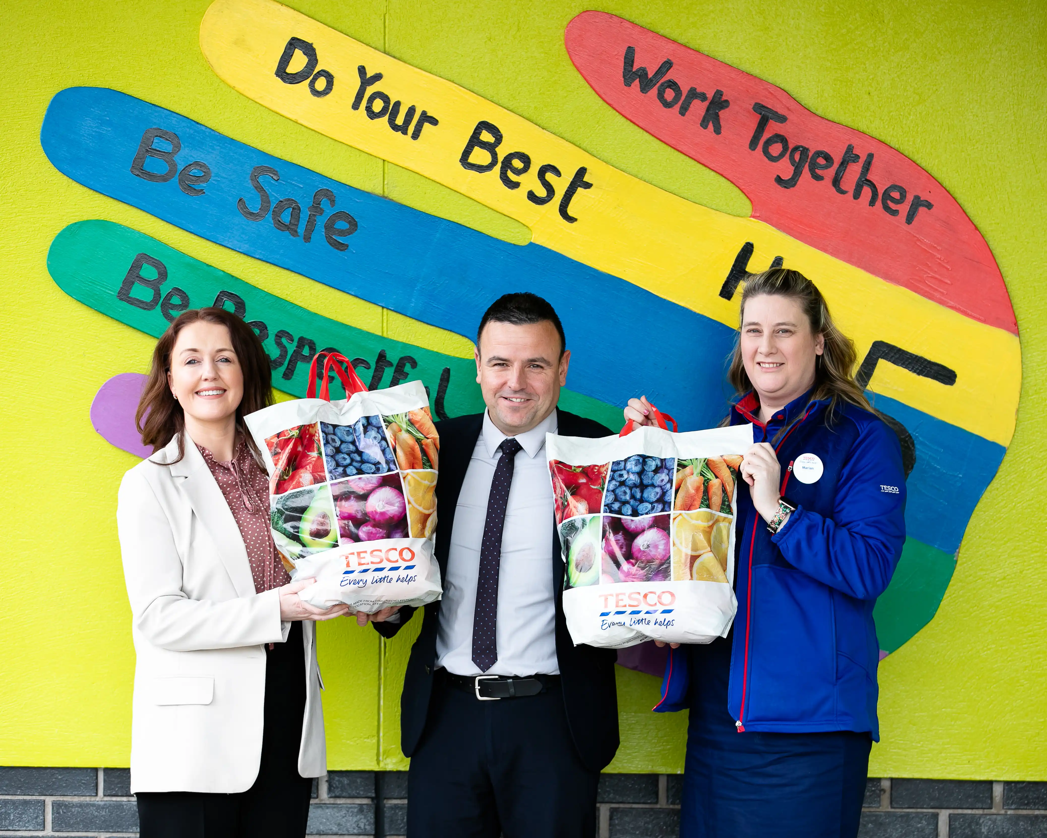 Business people with Tesco staff smiling