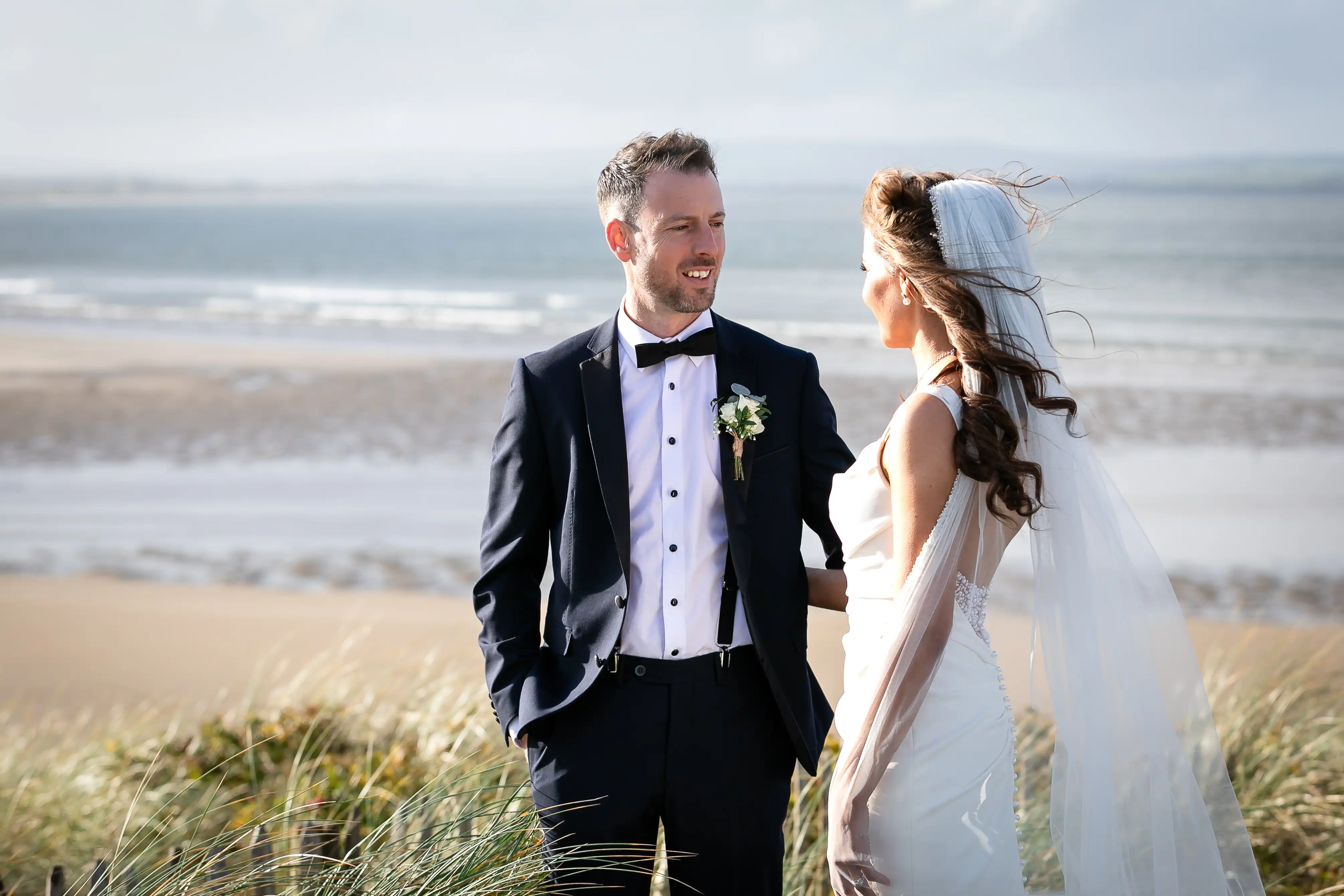 Bride and groom looking at each other on beach