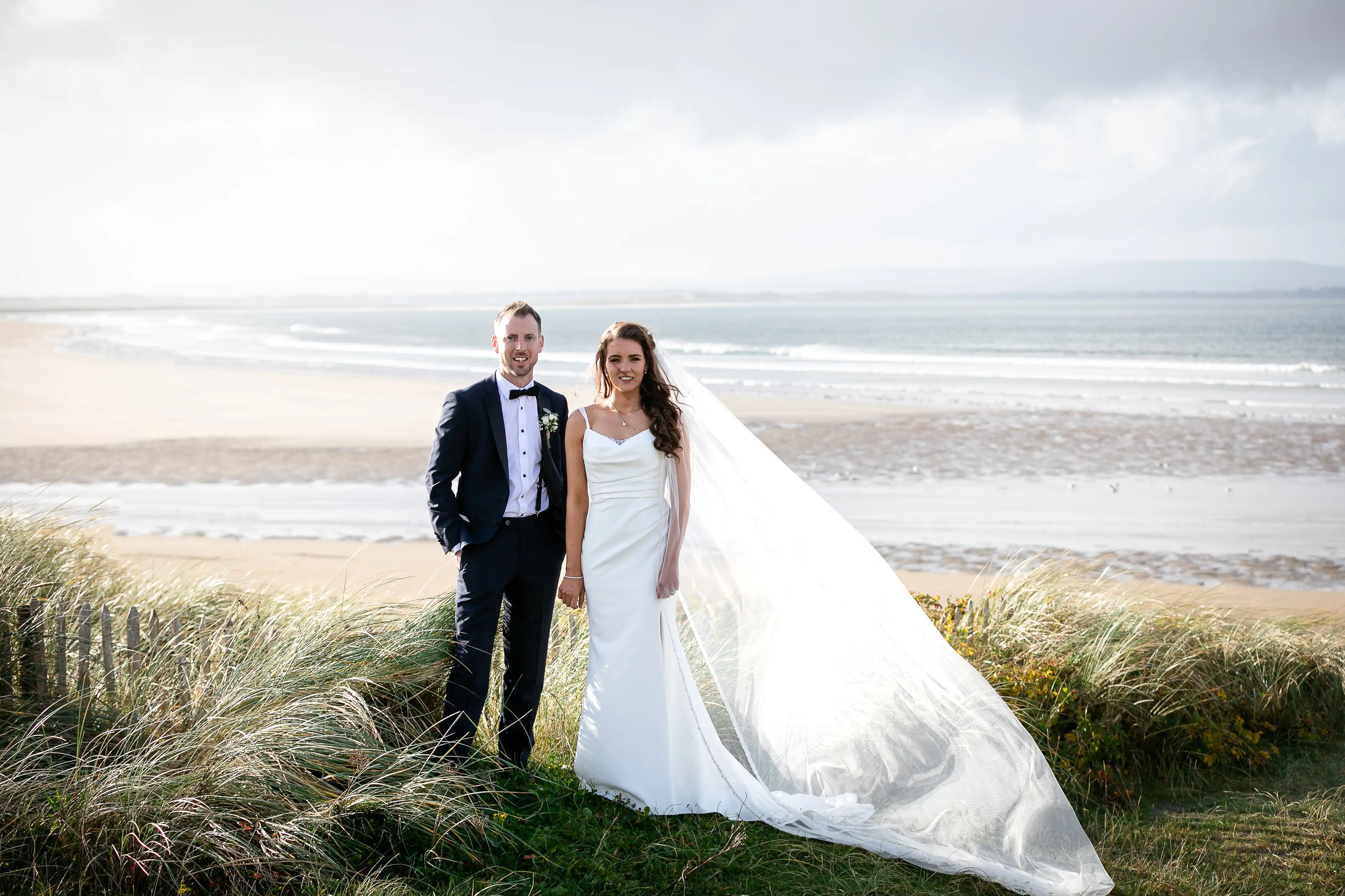 Bride and groom standing on beach