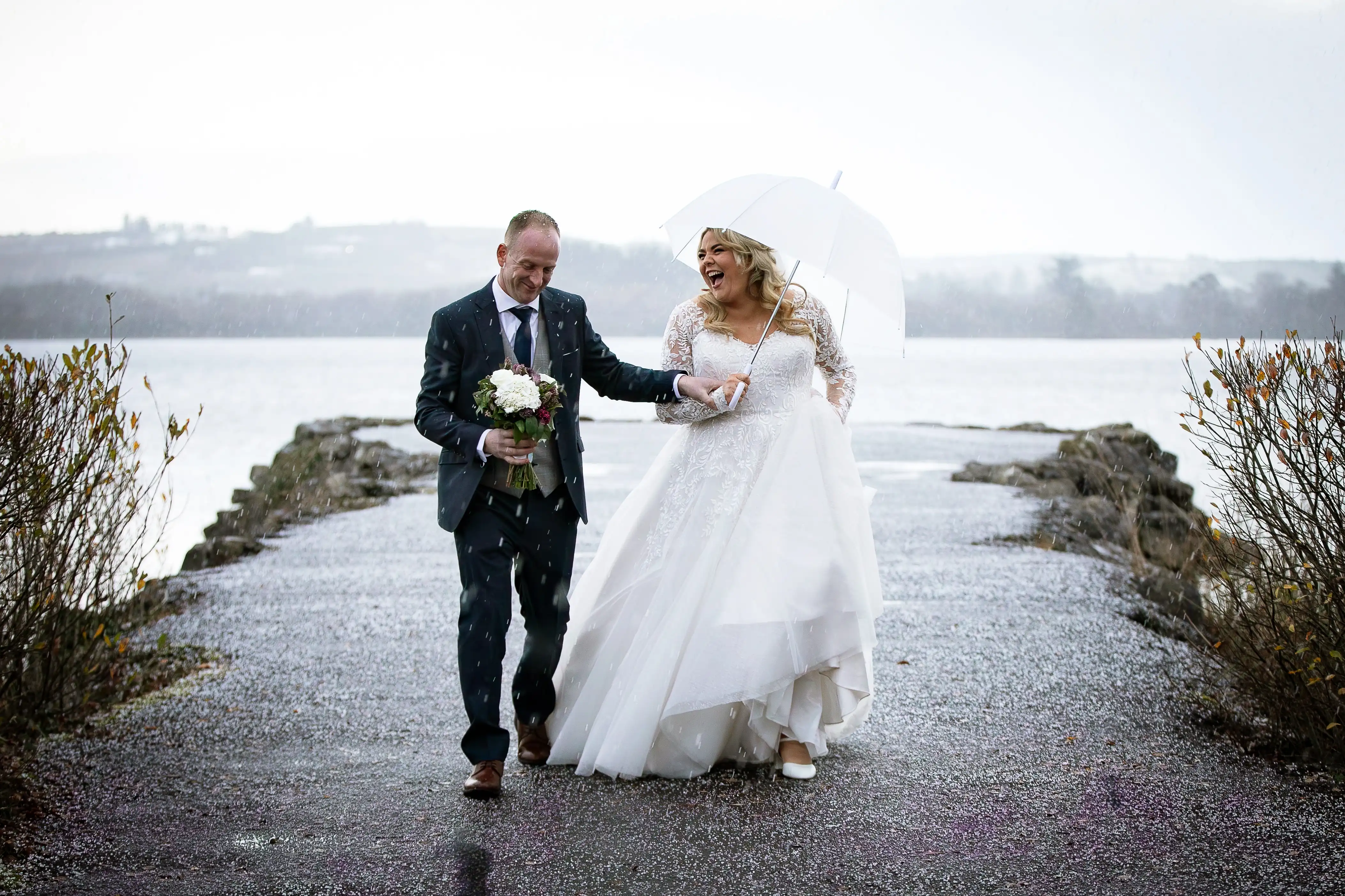 Bride and groom laughing in the rain
