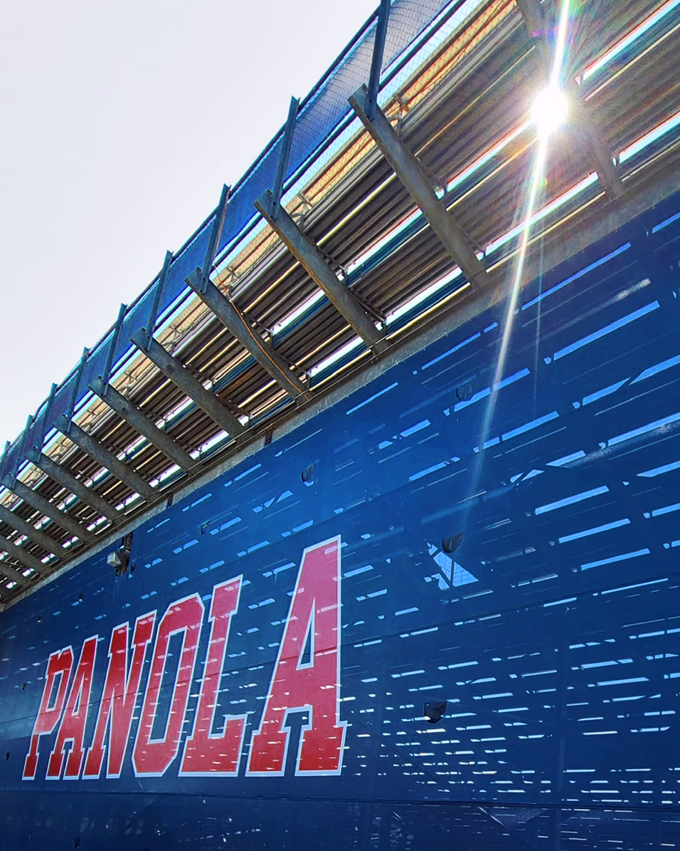 A large green sign reading "Welcome to Knight Stadium" on a stadium wall, with a cloudy blue sky above.