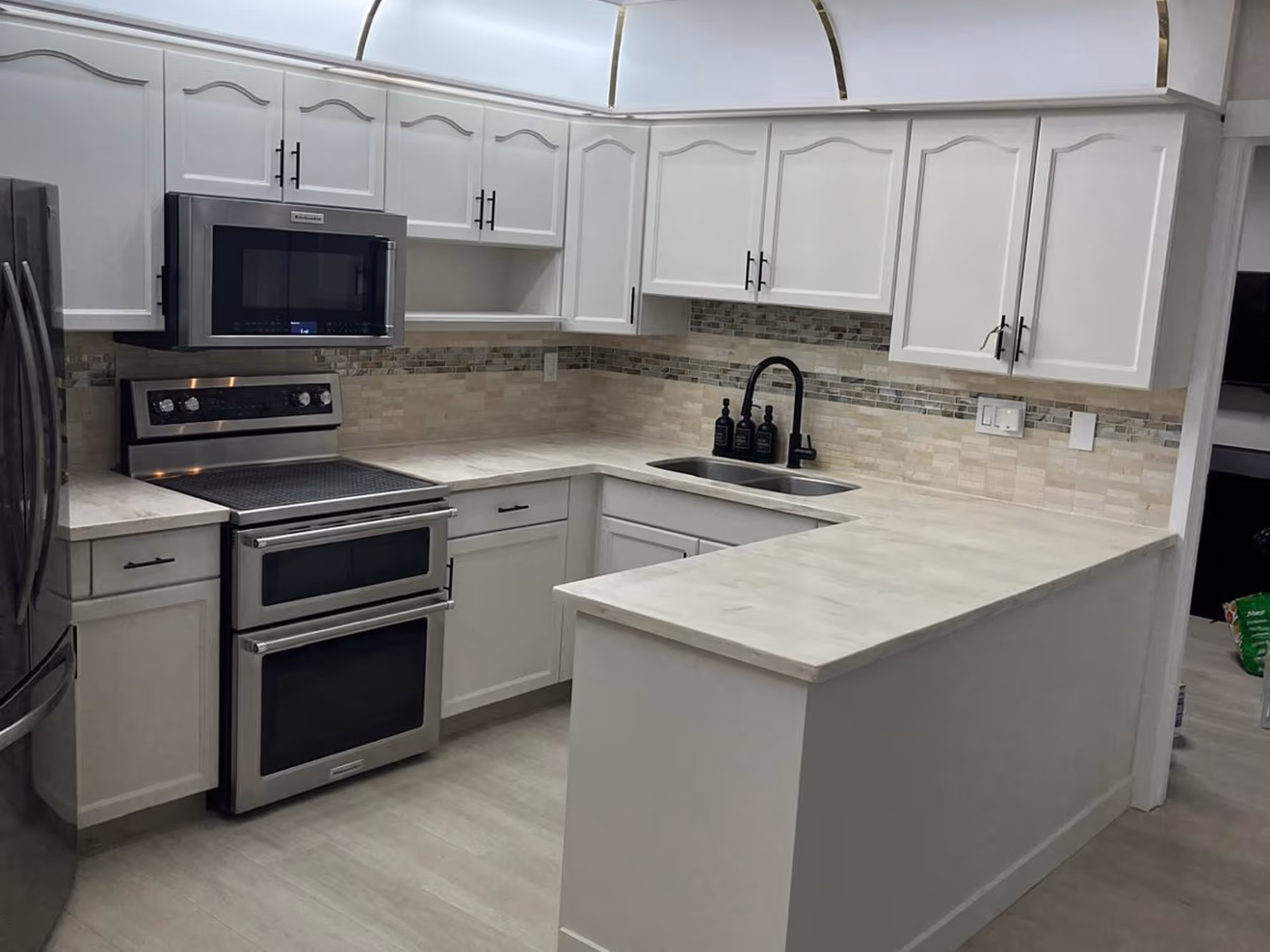 White kitchen cabinets with dark handles and light countertops