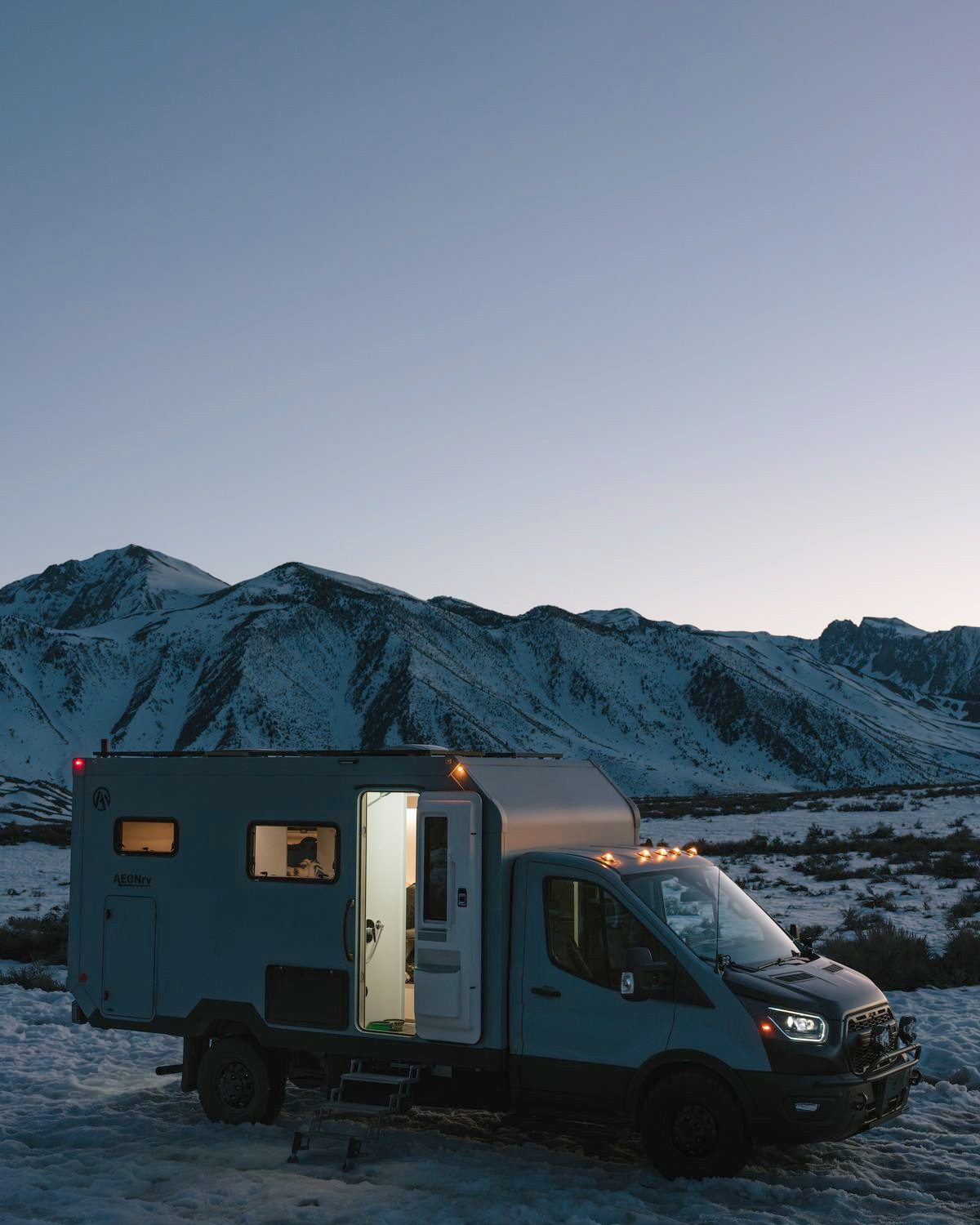 AEONrv at dusk with the door open and cabin lights on