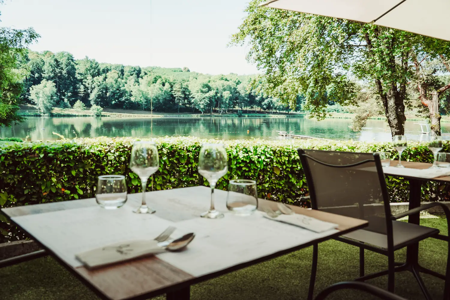 Terrasse ensoleillée du restaurant avec vue sur le lac – brasserie à Vigeois