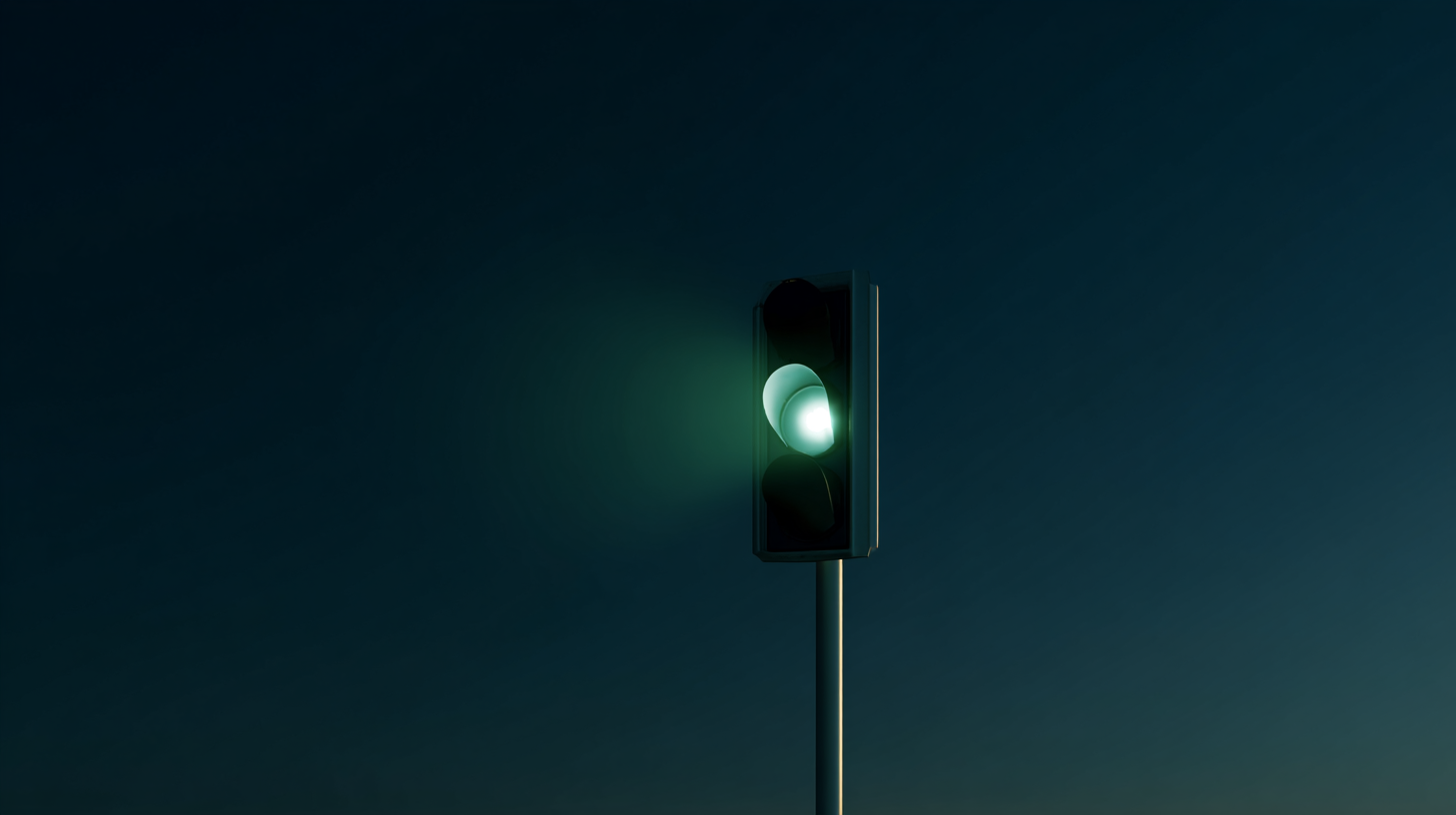 Single green traffic light glowing against a dark sky.