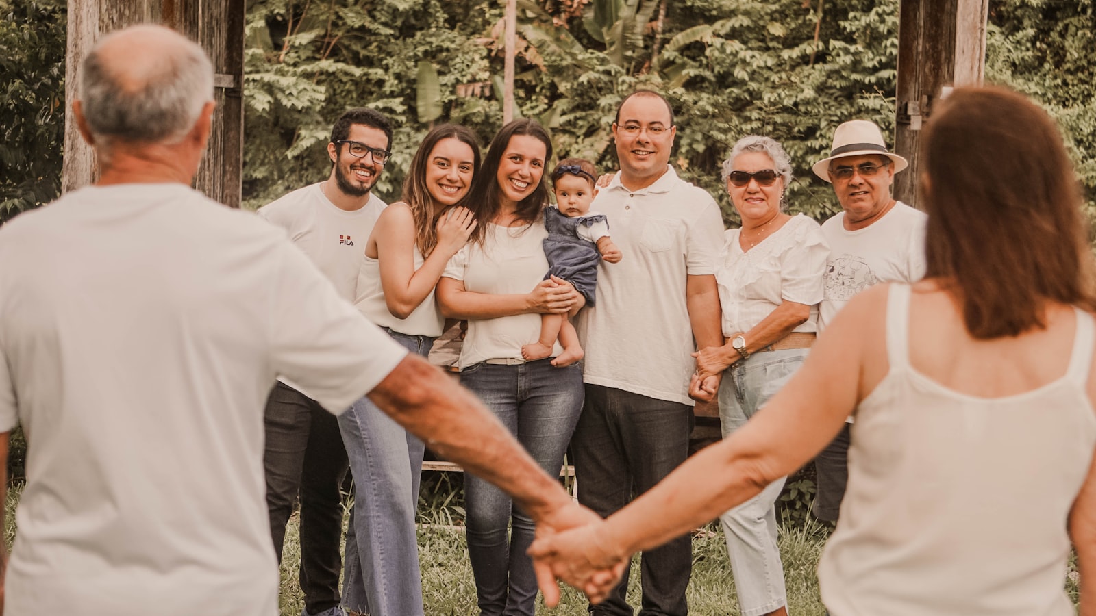 A multi-generational family holding hands