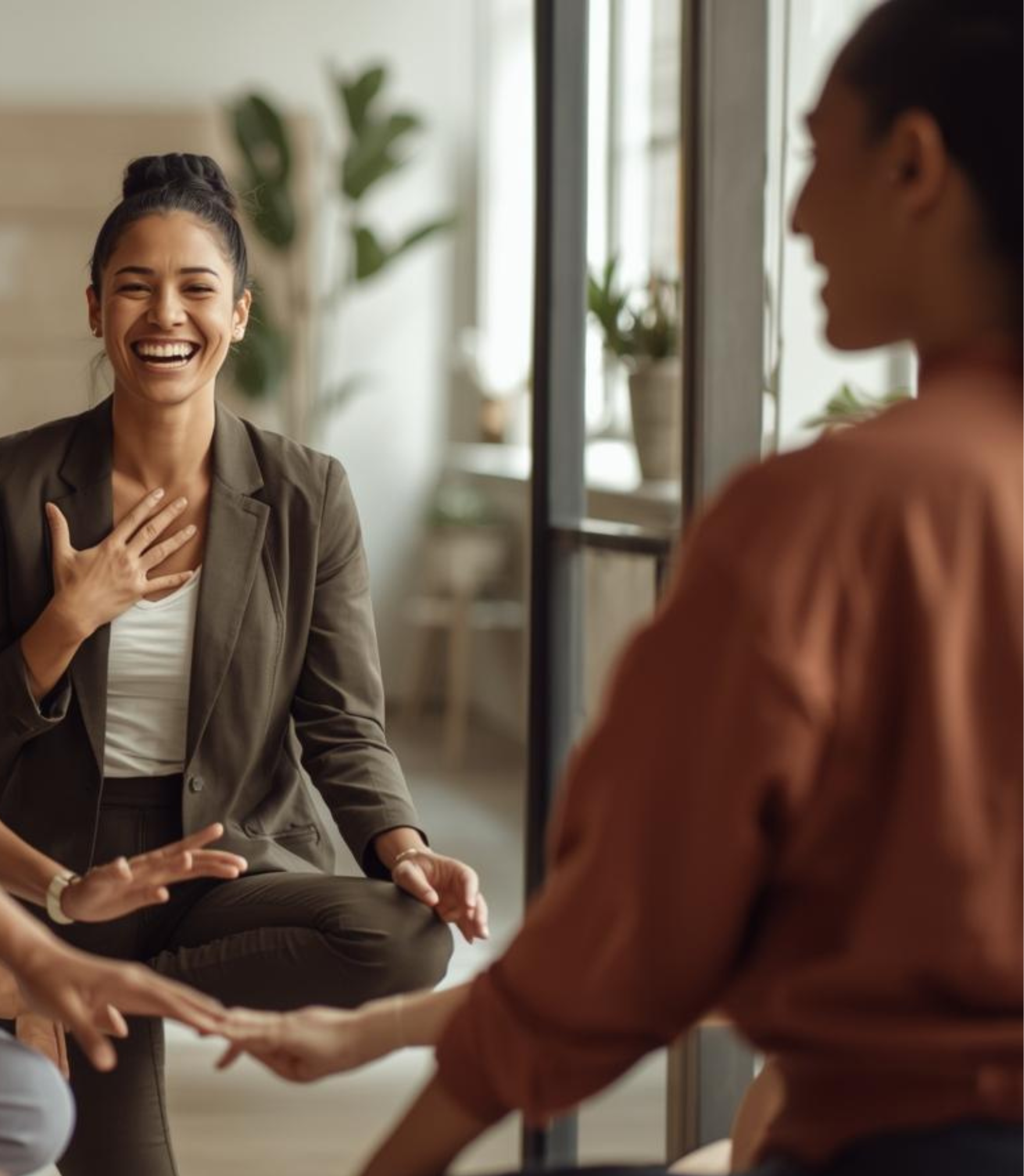 Group of smiling men sitting in armchairs with one hand on their chest in a bright room.