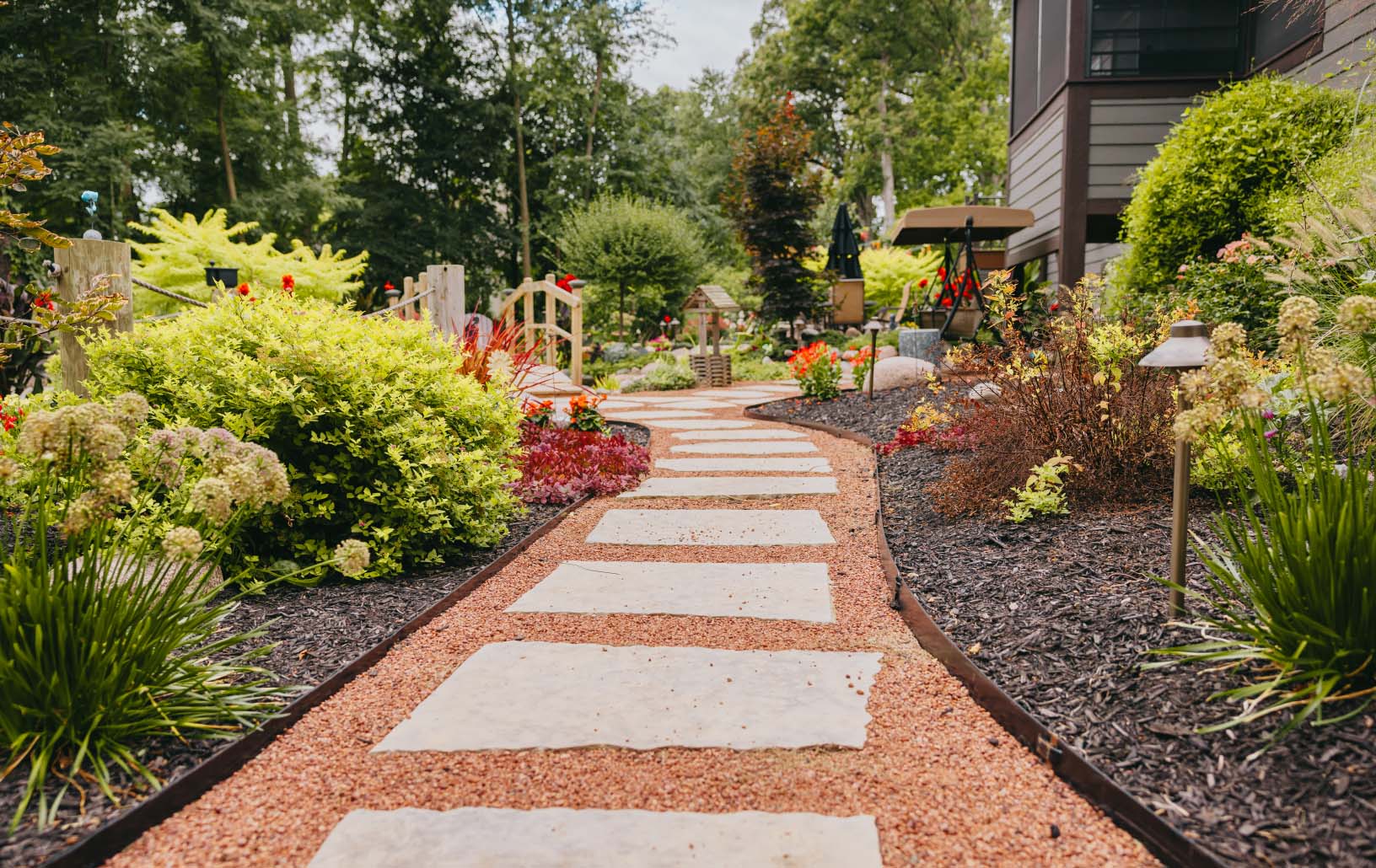 Curved stone garden pathway surrounded by colorful plants and flowers in a custom Chicago suburbs landscape.