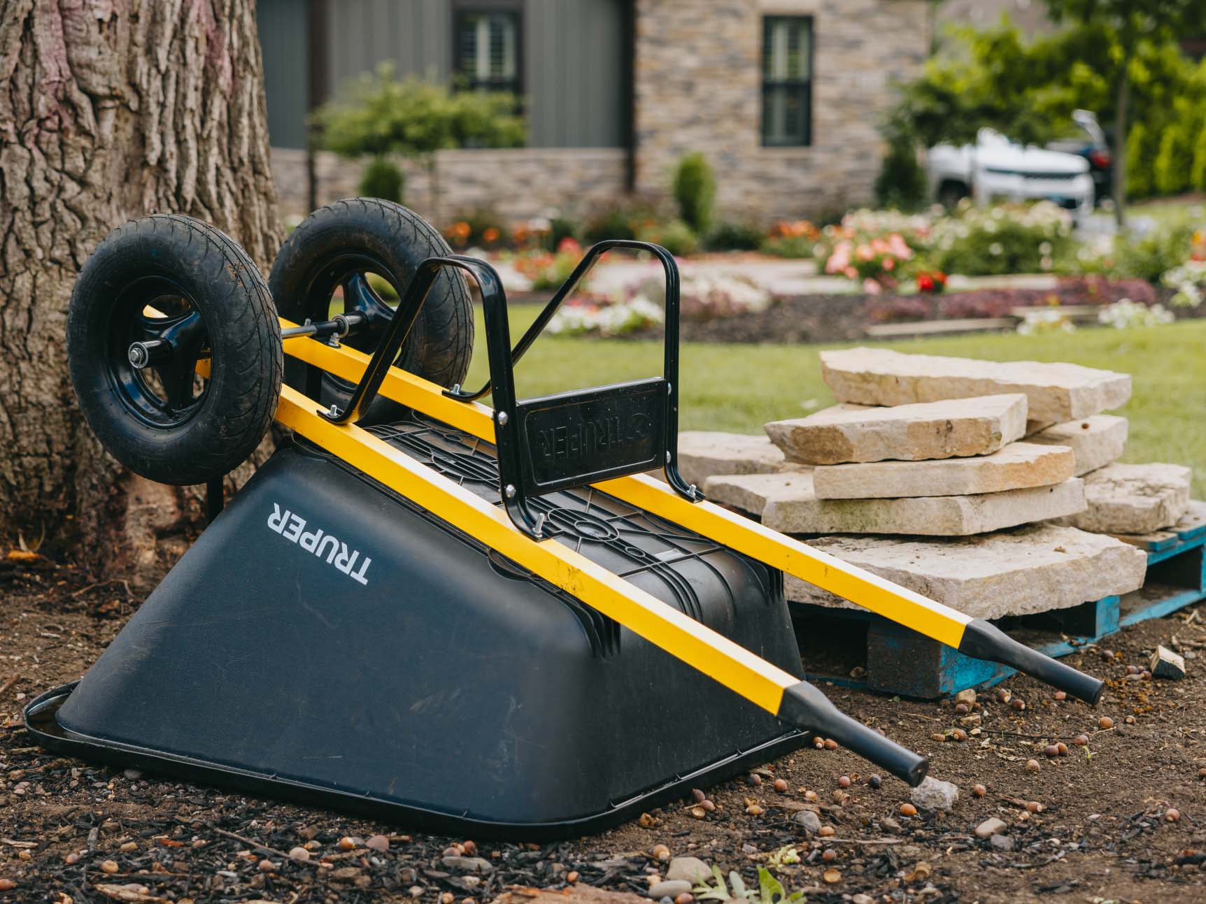 Upside-down wheelbarrow and stacked stone pavers ready for use in a backyard landscaping project in the Chicago suburbs.
