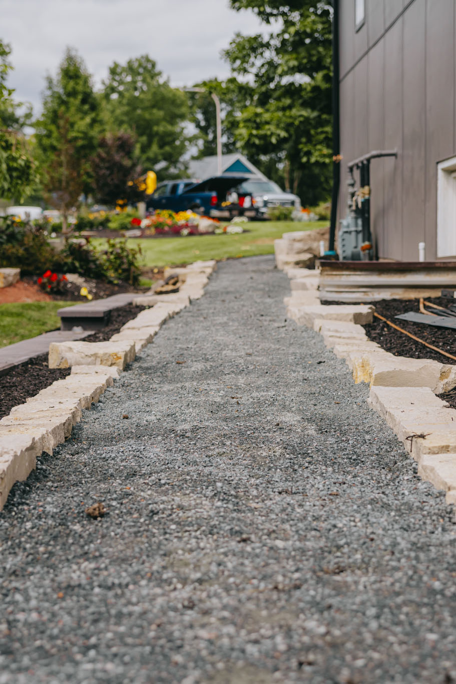 Side yard pathway under construction with stone edging and gravel base