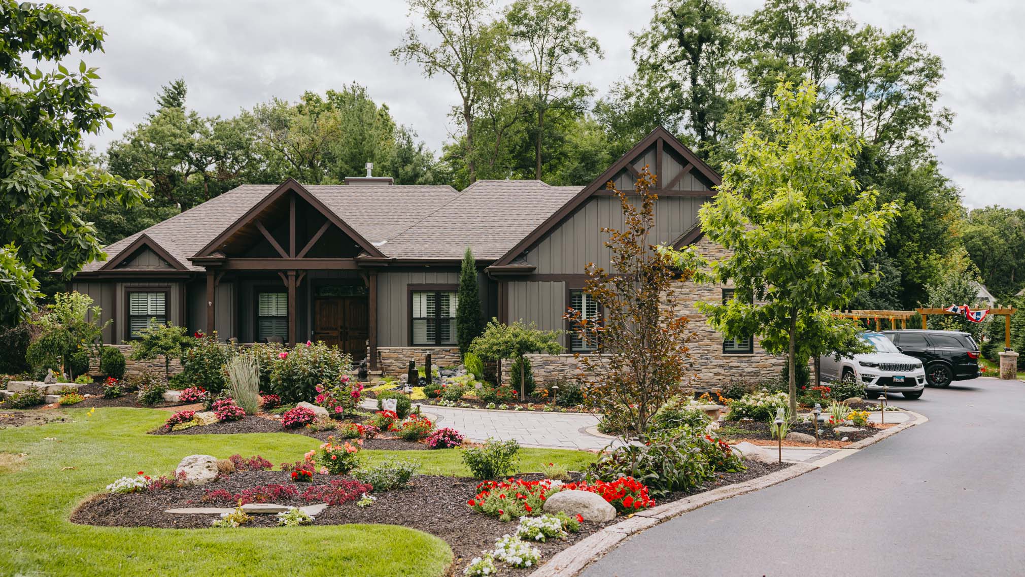 Beautiful landscaped home exterior with colorful flowers and stone accents