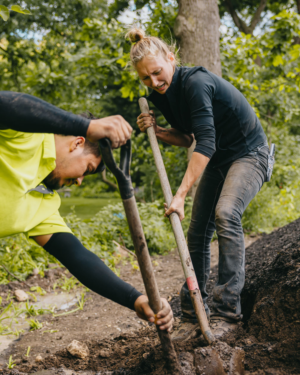 Custom Scapes and Designs team members digging and moving soil during a residential landscaping project in suburban Chicago.