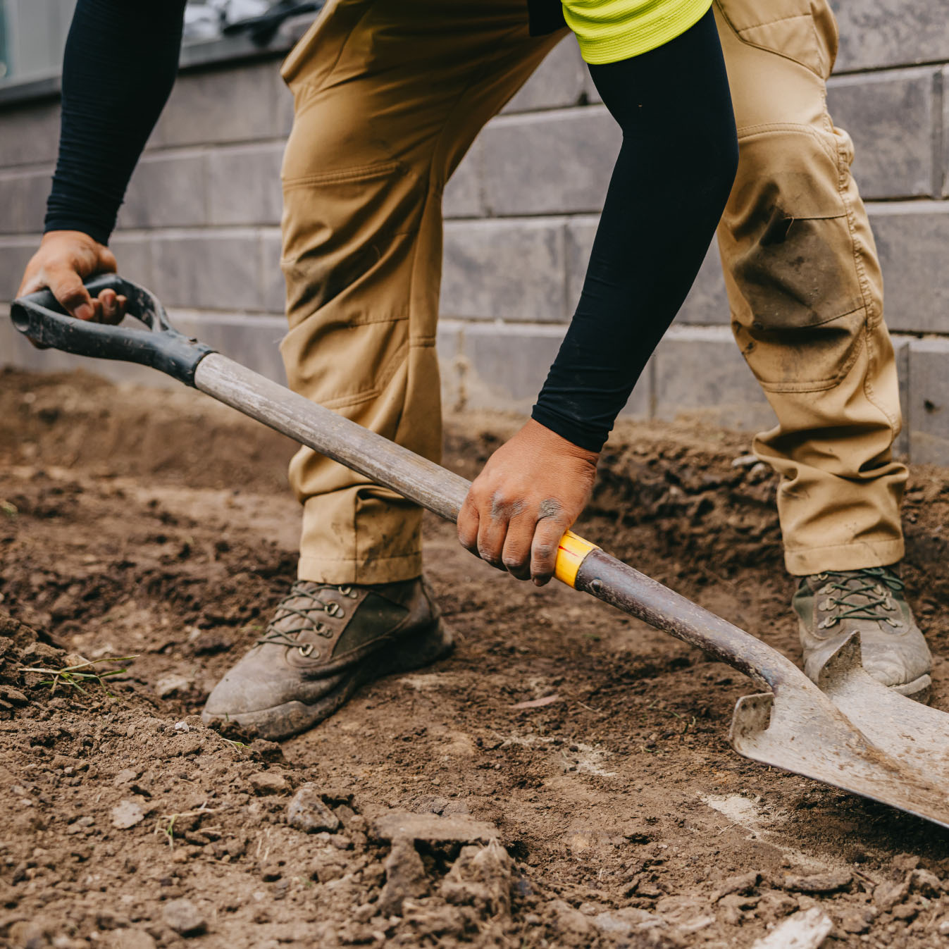 Landscaper preparing soil foundation for hardscape installation