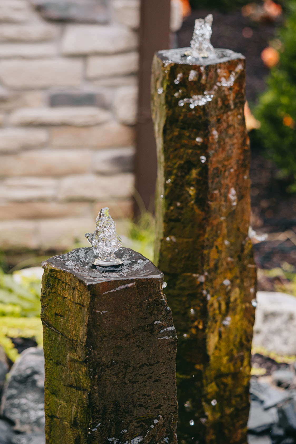 Close-up of modern stone water fountain with bubbling water and natural rock texture