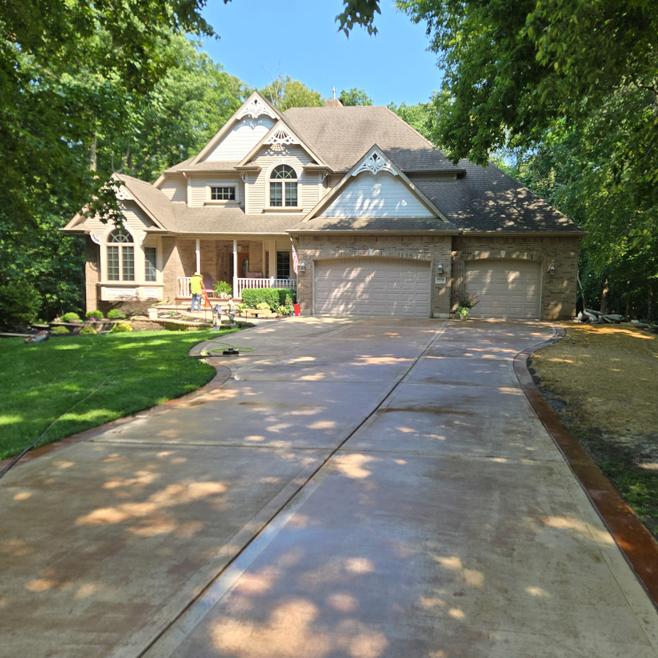 Completed driveway and front yard landscape featuring clean edging and manicured lawn.