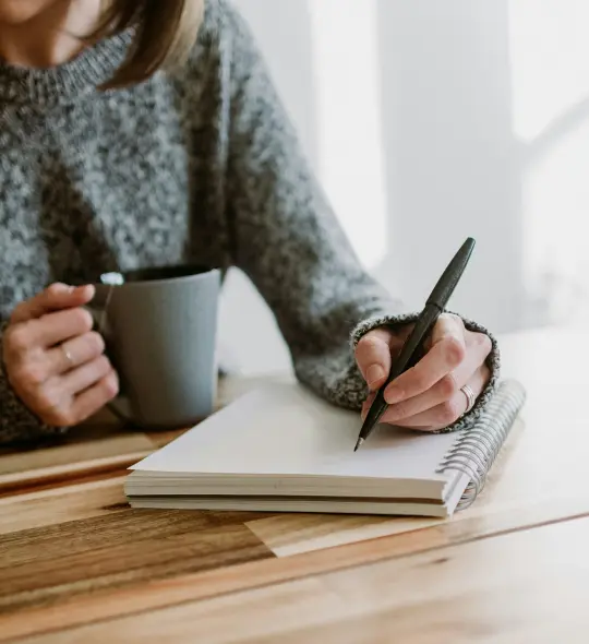 person reading a book and taking notes to improve skills