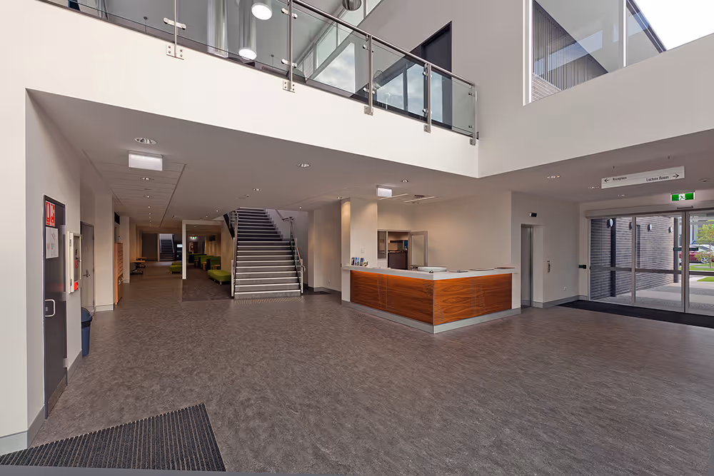 Inside a newer office building with stair case and reception desk
