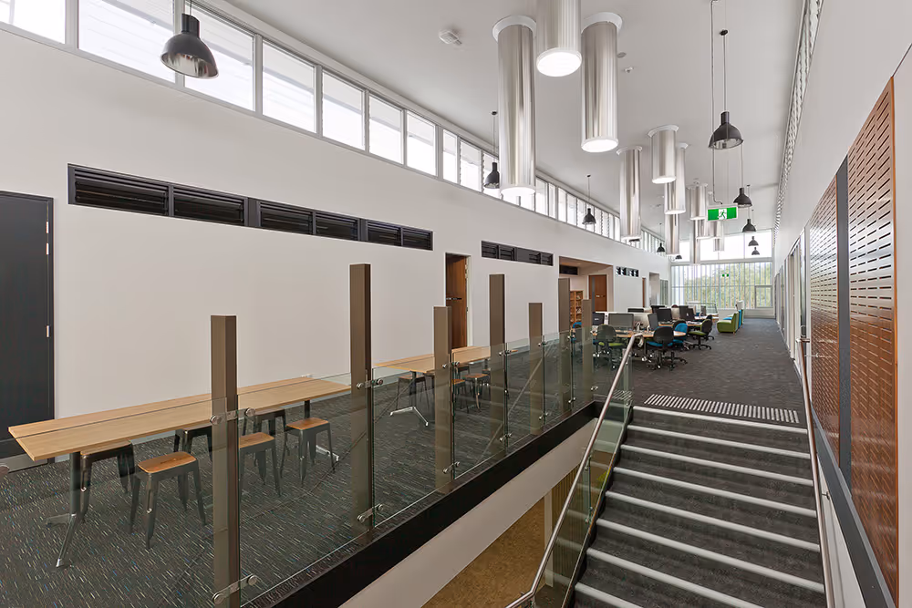 Inside a newly built building with stairs and tiled floors.