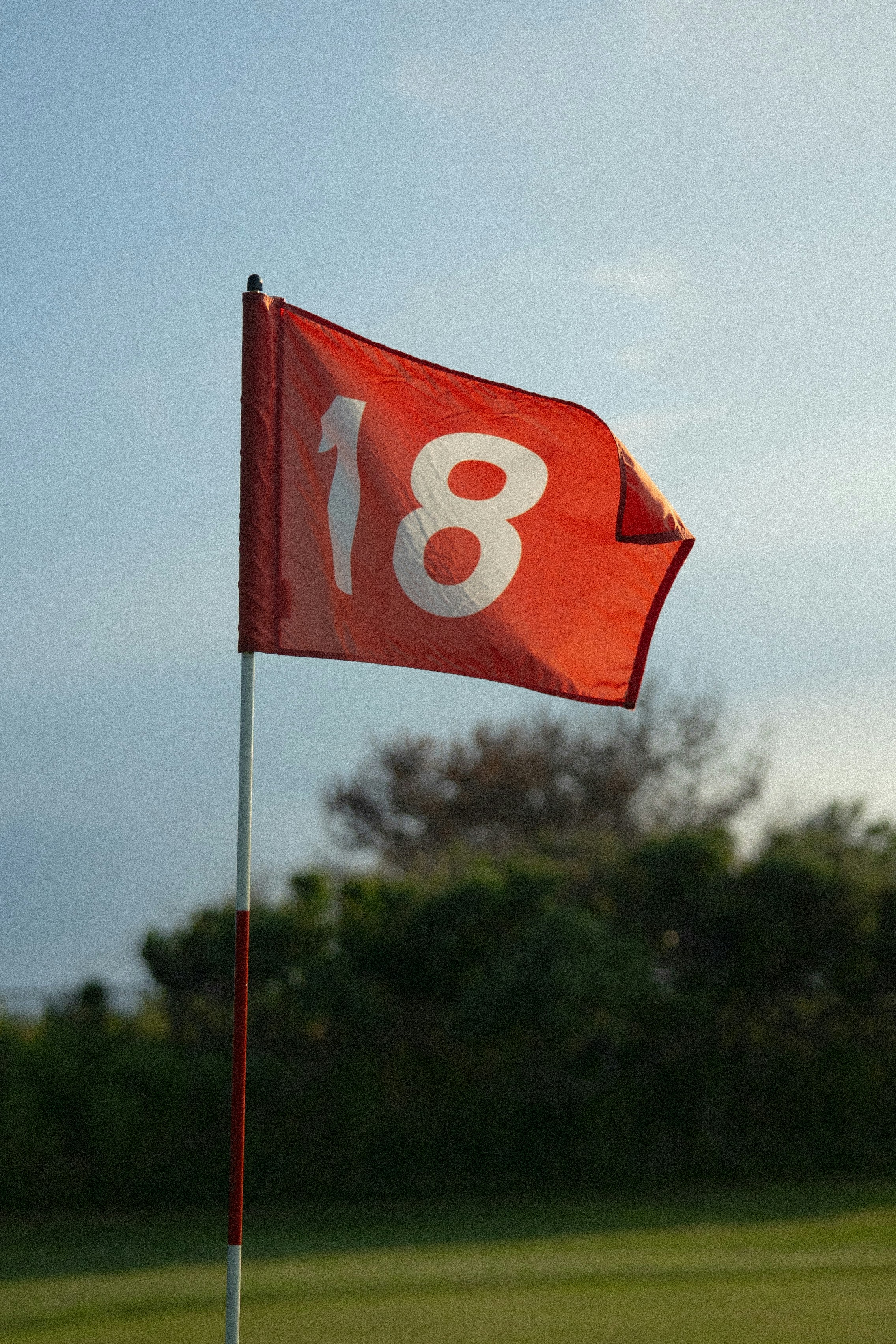 A golf flag on the 18th green
