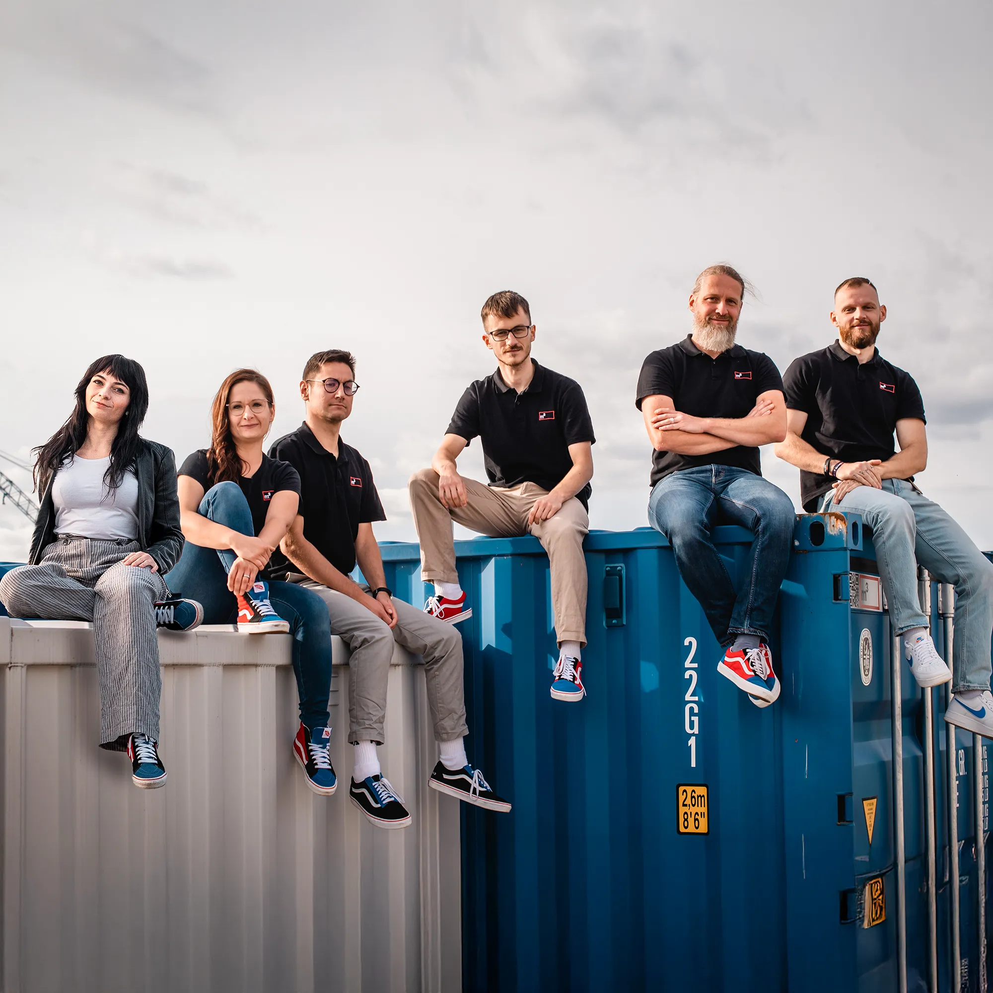 das Team von Mein Lagerraum3 auf Seecontainern sitzend