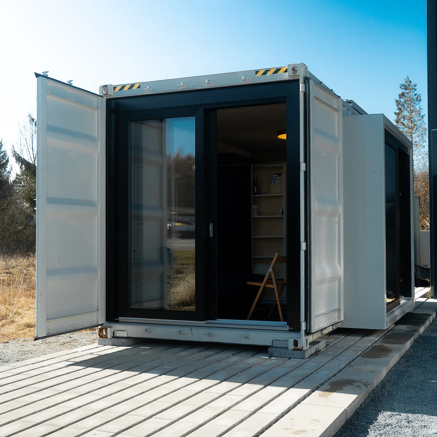 Container Tinyhouse mit Glaserker und Schiebetüren lichtdurchflutet